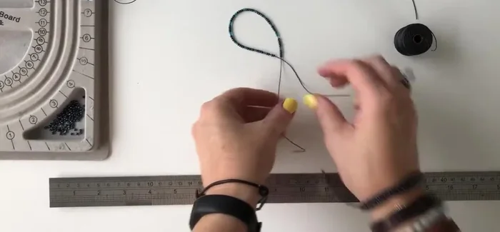 Add approximately 14 cm of seed beads to each twine. Use a beading clip to prevent beads from falling off.