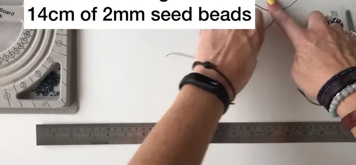 Add approximately 14 cm of seed beads to each twine. Use a beading clip to prevent beads from falling off.