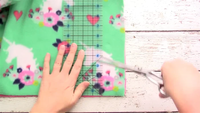 Measure 5 inches up from each corner and cut a 5x5 inch square from each corner.