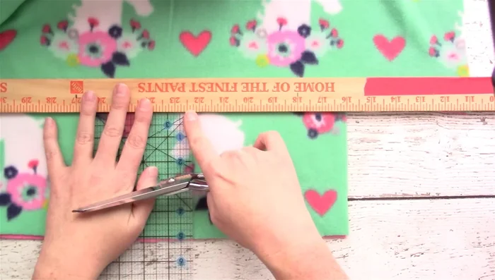 Cut 1-inch wide strips, 5 inches deep, along the entire edge of the blanket.