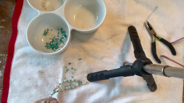 Attach the clasp. Open a jump ring, attach it to the crimped end, and then attach your clasp.