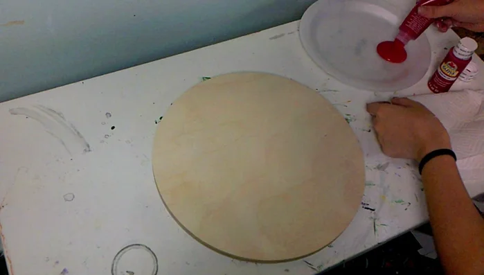 Paint the wooden round solid red.