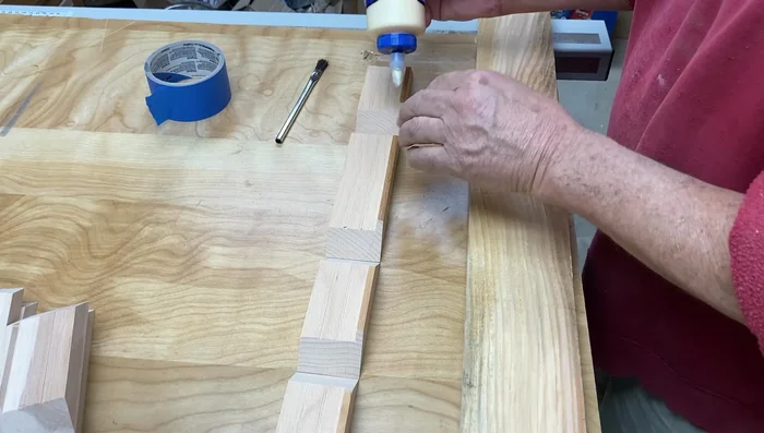 Cut the curve on the top of the outer box using a jig, a flush trim router bit, and a plunge router. Make multiple passes to avoid tear-out.