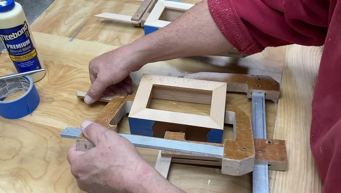 Cut the curve on the top of the outer box using a jig, a flush trim router bit, and a plunge router. Make multiple passes to avoid tear-out.