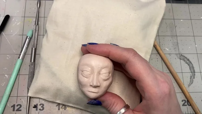 Add and shape the lips, creating a Cupid's bow; add more clay than needed, then blend and refine.