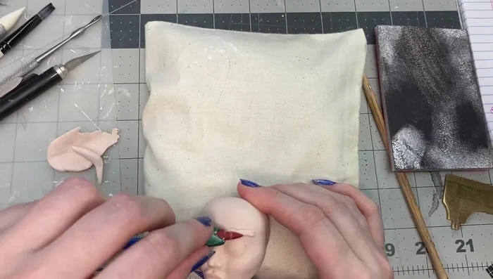 Refine the eyelids and add clay to the top of the head and jaw area.