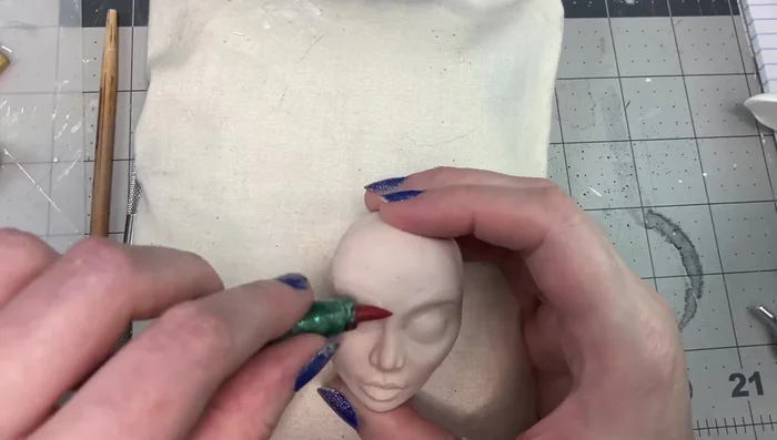 Refine the eyelids and add clay to the top of the head and jaw area.
