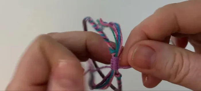 Tie a simple overhand knot at the end of each bunch of threads and trim the excess.