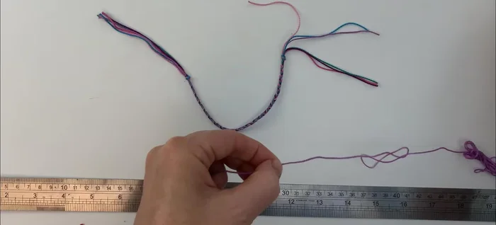 Position your 40cm thread underneath the overlapping section of the bracelet, pulling it to the middle.