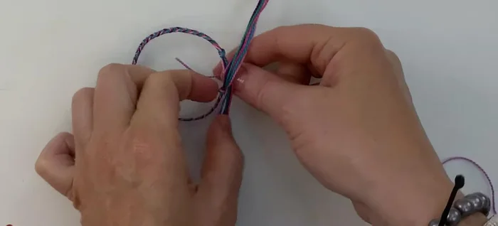 Position your 40cm thread underneath the overlapping section of the bracelet, pulling it to the middle.