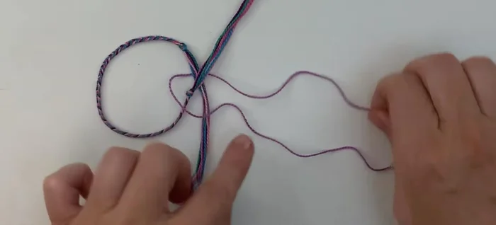 Continue the square knot by alternating sides. Bring the right cord over and form a loop. Then bring the left cord down, under, and up through the loop on the right. Repeat this process, alternating left and right, until you reach your desired knot length (about 10 stitches is suggested).