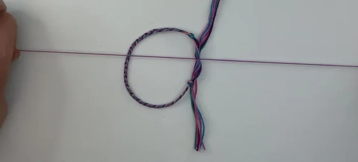 Continue the square knot by alternating sides. Bring the right cord over and form a loop. Then bring the left cord down, under, and up through the loop on the right. Repeat this process, alternating left and right, until you reach your desired knot length (about 10 stitches is suggested).