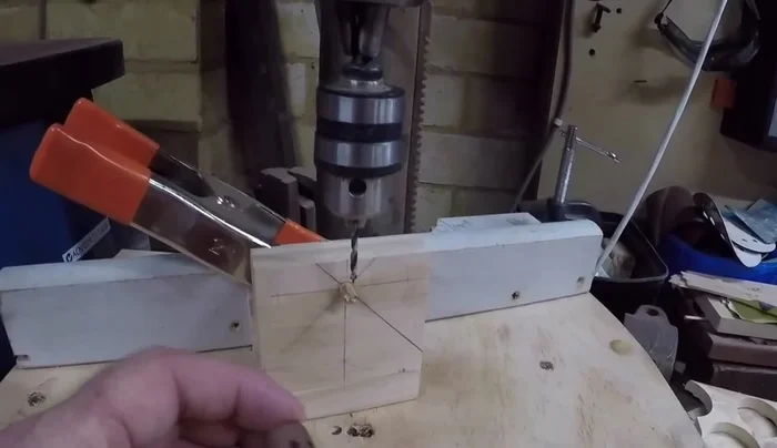 Prepare a jig for creating spoke holes. Use a block of wood with a 6 mil hole for a 6 mil dowel (axle hole size). Draw lines at 45 degrees for eight spokes.