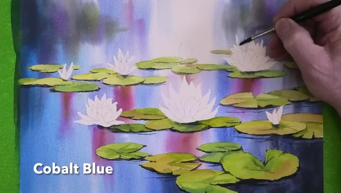 Paint the water lilies: Shadows on petals facing the viewer using watery cobalt blue, and use cadmium orange for the other petals, adding magenta where needed.