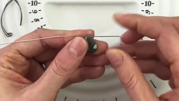 Thread the wire through the bead, leaving significantly more wire on one side than the other.
