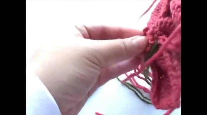 Insert the bud into the center of the flower and sew the remaining loose ends to the bud and petals.