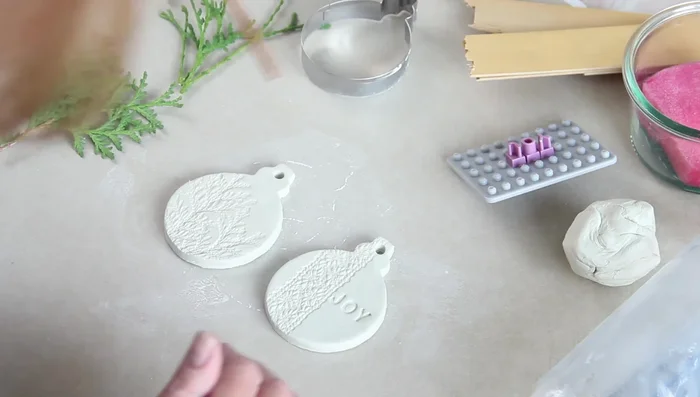 Press wooden decorations into the clay.