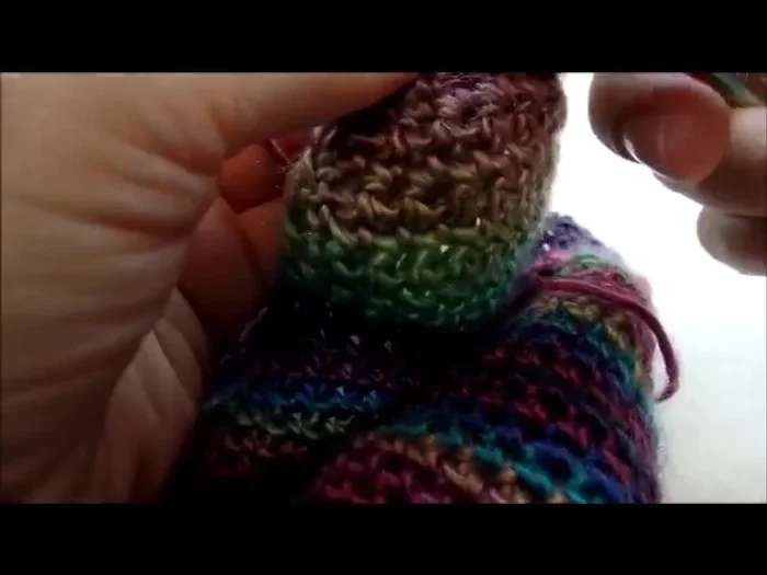 Make 3 small pom-poms and 1 large pom-pom. Sew or glue the small pom-poms to the ends of the ear flaps and the large pom-pom to the top of the hat.