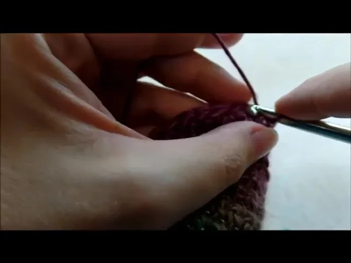 Make 3 small pom-poms and 1 large pom-pom. Sew or glue the small pom-poms to the ends of the ear flaps and the large pom-pom to the top of the hat.