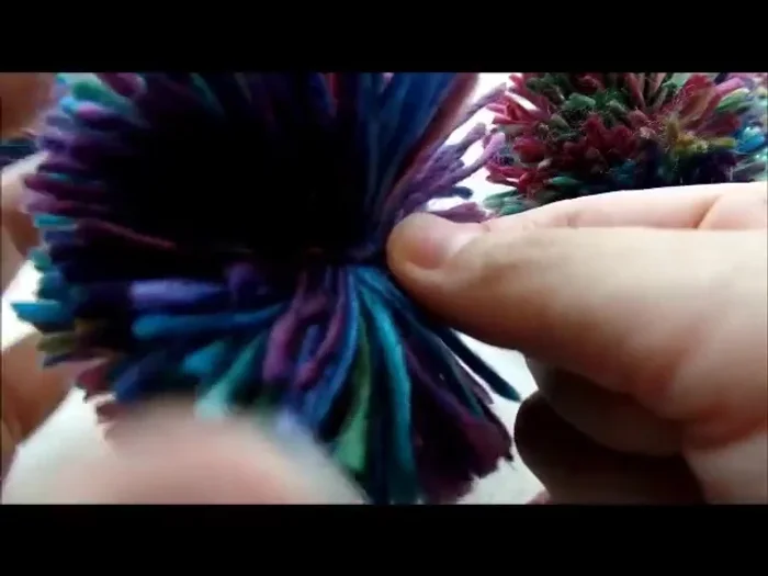 Make 3 small pom-poms and 1 large pom-pom. Sew or glue the small pom-poms to the ends of the ear flaps and the large pom-pom to the top of the hat.