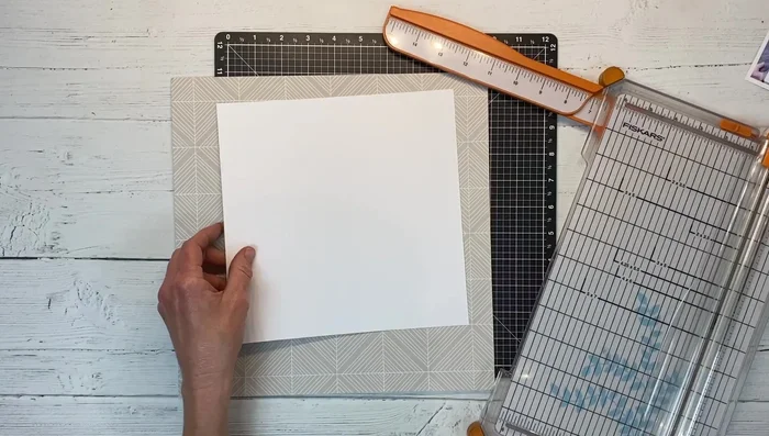 Prepare your base materials: Choose card stock and pattern paper for your background and center panels. Cut and arrange the elements as desired.