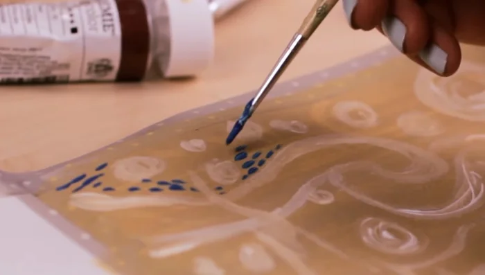 Start painting with a darker shade of blue using short, thick brush strokes. Leave spaces between each stroke; don't aim for seamless lines. Follow the white outlines from your sketch.