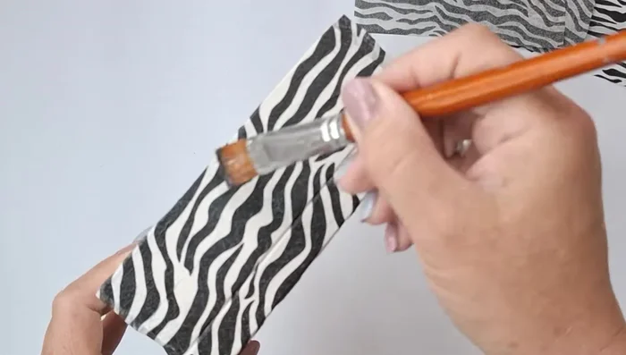 Remove excess napkin and smooth the surface with sandpaper. Reapply decoupage glue to the edges.