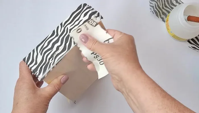 Remove excess napkin and smooth the surface with sandpaper. Reapply decoupage glue to the edges.