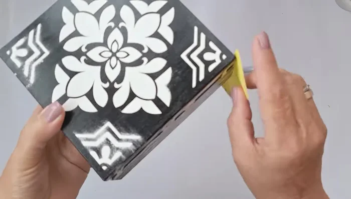 Sand the putty pattern to smooth the surface, clean it, and apply another layer of glossy varnish. Let it dry naturally.