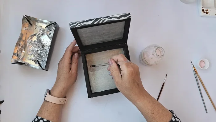 Apply glue for silver leaf to the silver painted areas and apply silver leaf/flakes, removing excess with a brush. Polish with a soft cloth and seal with shellac or protective varnish.