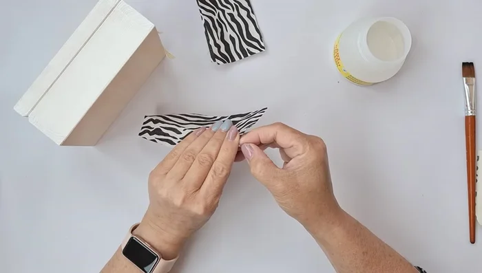 Remove excess napkin and smooth the surface with sandpaper. Reapply decoupage glue to the edges.