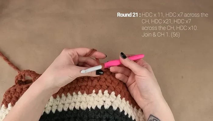 Round 21: Work hdc in first 11 stitches, hdc 7 across first handle, hdc in next stitch, hdc in next 20 stitches, hdc 7 across second handle, hdc in remaining stitches.