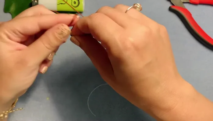 Find the middle of the two-yard cord and tie a loose overhand knot to prevent beads from falling off.