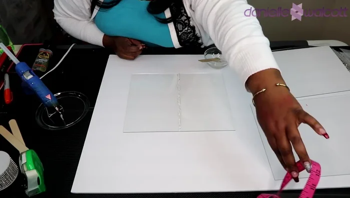 Carefully place a second glass pane onto the epoxy, ensuring alignment with the marked center. Hold in place for 5-10 minutes to allow the epoxy to set. (Consider using assistance to hold the glass panes in place.)