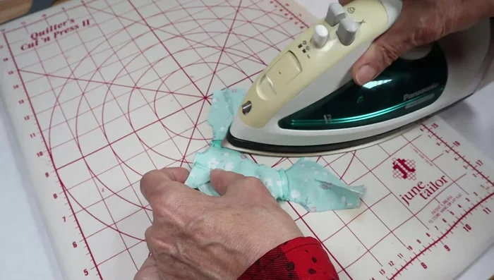 Fold and press the armholes.