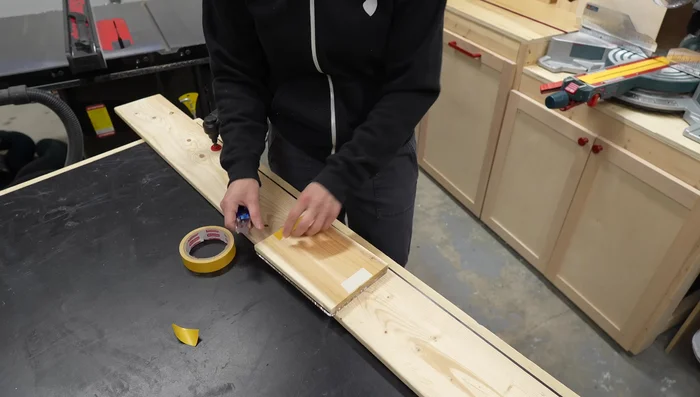 Attach the template and wood piece to a sacrificial backer board using double-sided tape.