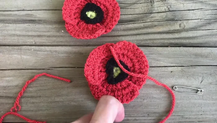 (Optional) Create a small center for a lapel pin by creating a slip ring and working 12 single crochets into it. Attach to the back of the poppy with a safety pin.