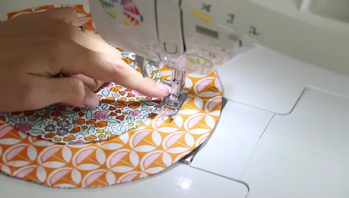 Create the drawstring casing: Using the sewing machine, sew along the inner edge of the large circle, creating a channel for the drawstring. Sew twice to ensure the casing is secure and wide enough for the cord or ribbon.