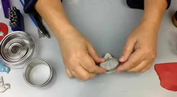 Gently demold the clay piece by pressing the mold down on a work surface and pulling back.