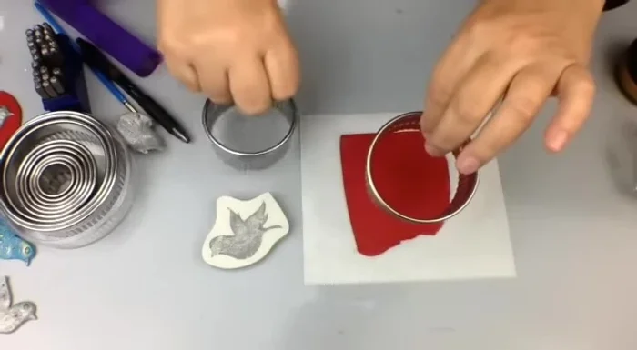 Using ruffled edge cookie cutters, cut out the base for the ornament, creating a frame effect with two different sizes.