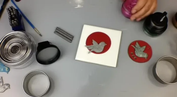 Apply gilding polish using a finger or small brush, highlighting the details of the dove and base. Add metal letter stamps for personalization.