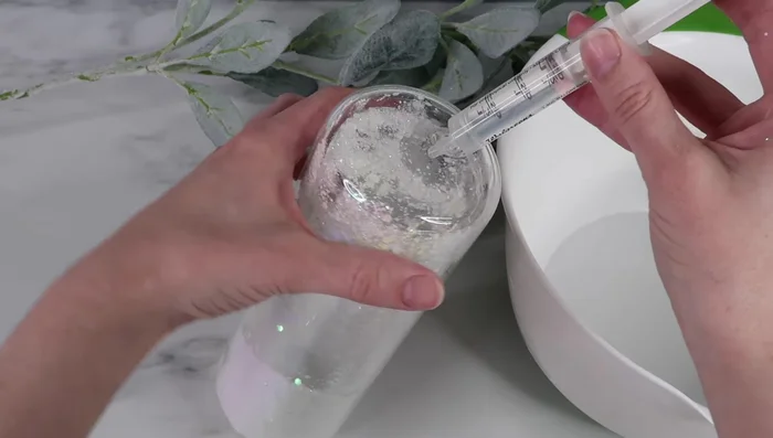 Slowly add the liquid mixture, tilting and rotating the tumbler to minimize air bubbles.