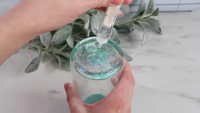 Gently manipulate any remaining air bubbles to the opening and carefully add more liquid mixture to fill the space. If a large bubble persists, consider using a syringe with a fine tip.