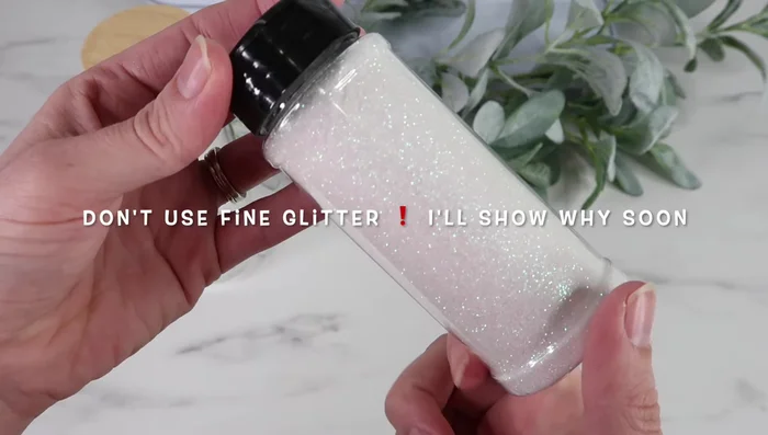 Apply tape around the rim of the tumbler to contain glitter spillage.