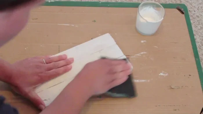 Sand the edges and surface of the wood to create a rustic look, paying attention to the grain.