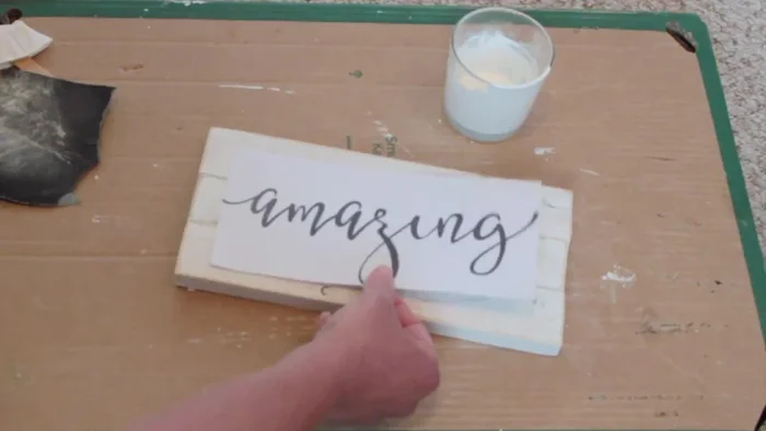 Print lettering on regular paper (not reversed). Scribble on the back of the paper, position it on the sign, and tape it down. Trace the lettering onto the wood using a sharp point.