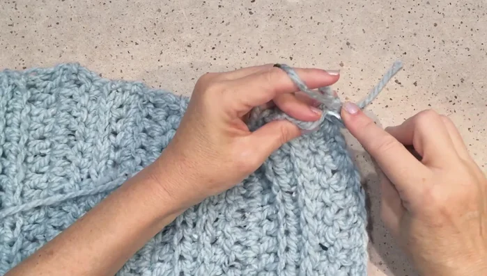 Finish bottom edge: Single crochet around the bottom edge. Then, create ribbing along the front edges by working single crochets and slip stitches.