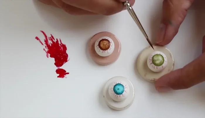 Draw lines from the outside to the inside of the iris, mixing random shades to create depth and realism. Use reference pictures for guidance.