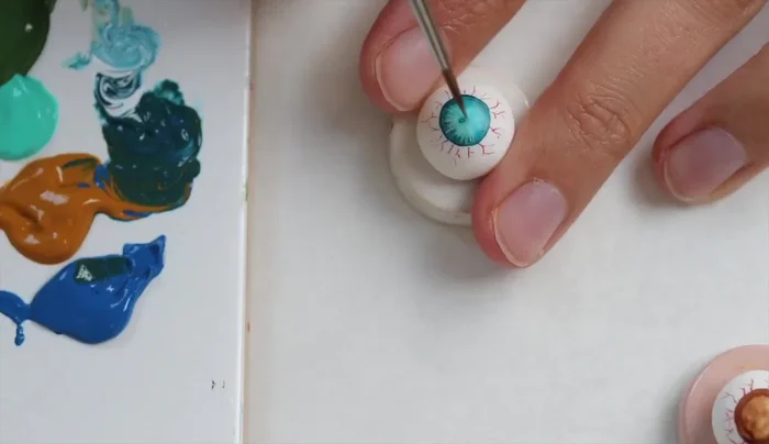 Draw lines from the outside to the inside of the iris, mixing random shades to create depth and realism. Use reference pictures for guidance.