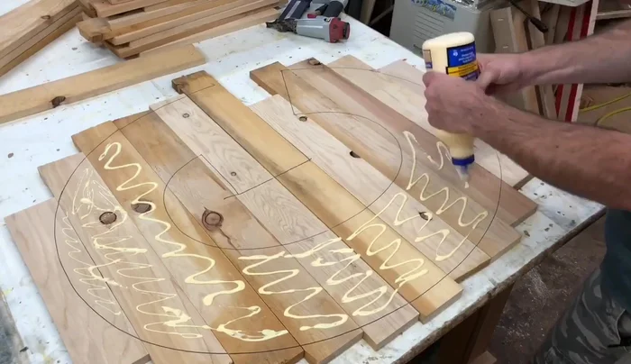 Glue and nail the slats: Apply wood glue to the traced lines on the backer board. Place the boards on the glue, ensuring they align with the traced lines. Secure the boards using a brad nailer.